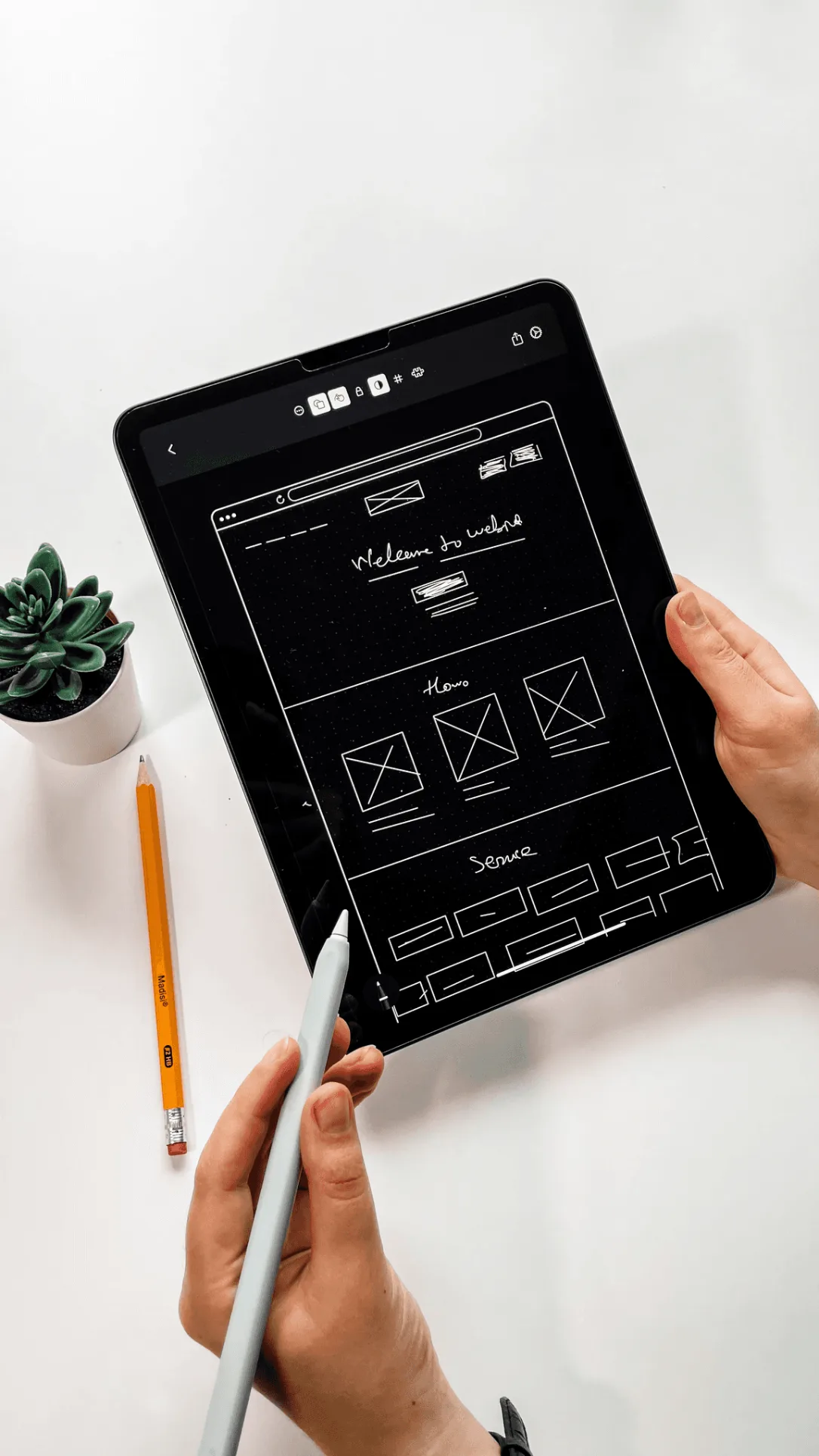 Tablet showing hand-drawn website wireframes